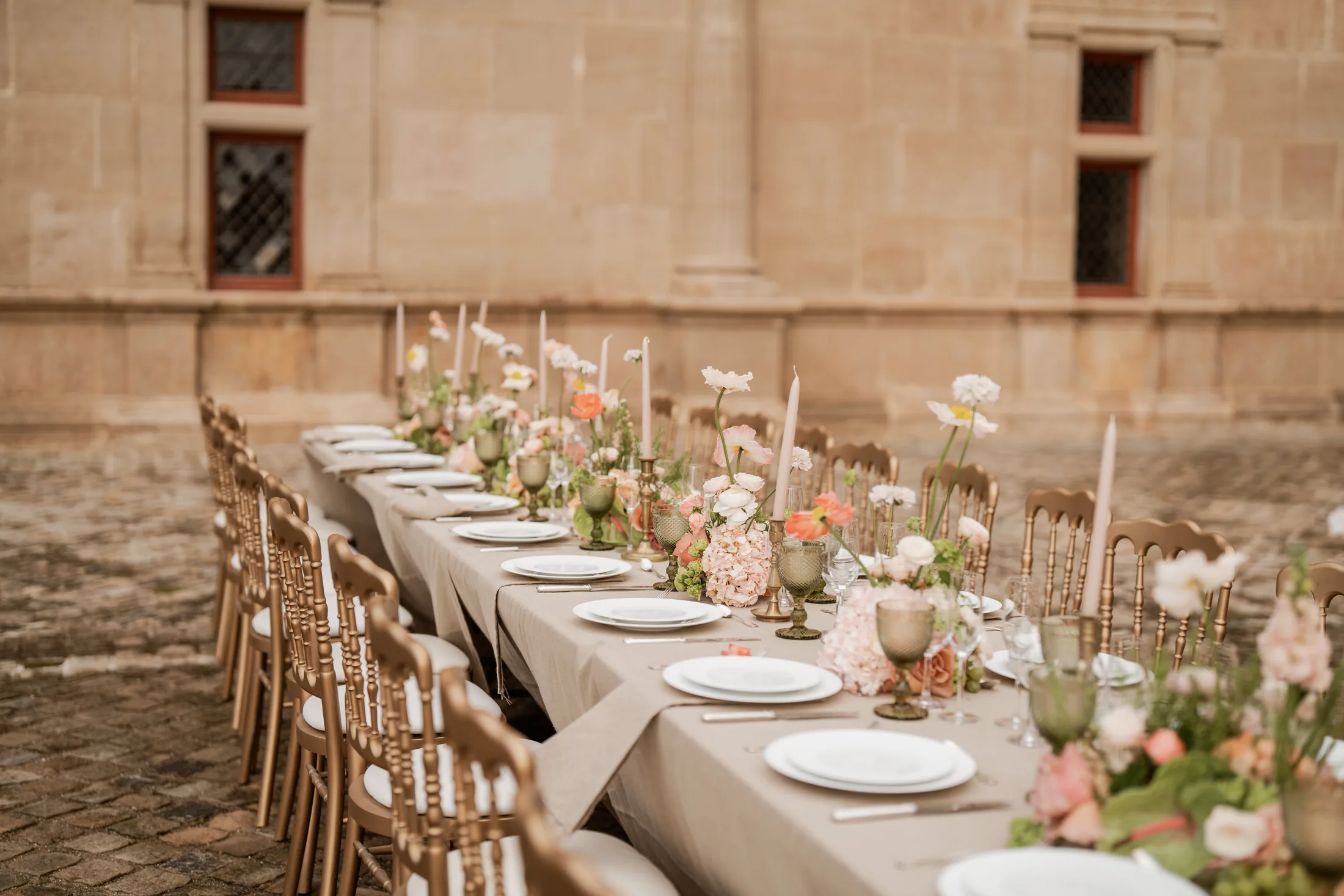 A long table in the courtyard of Château de Bournazel at golden hour