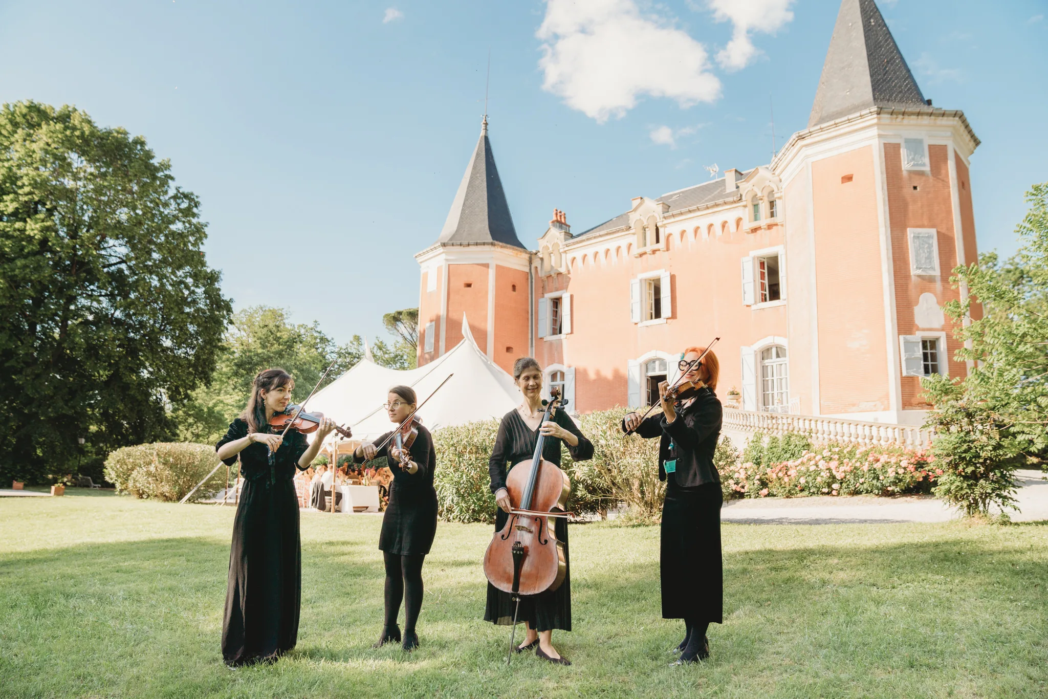 A string quartet playing on the lawn in front of the château