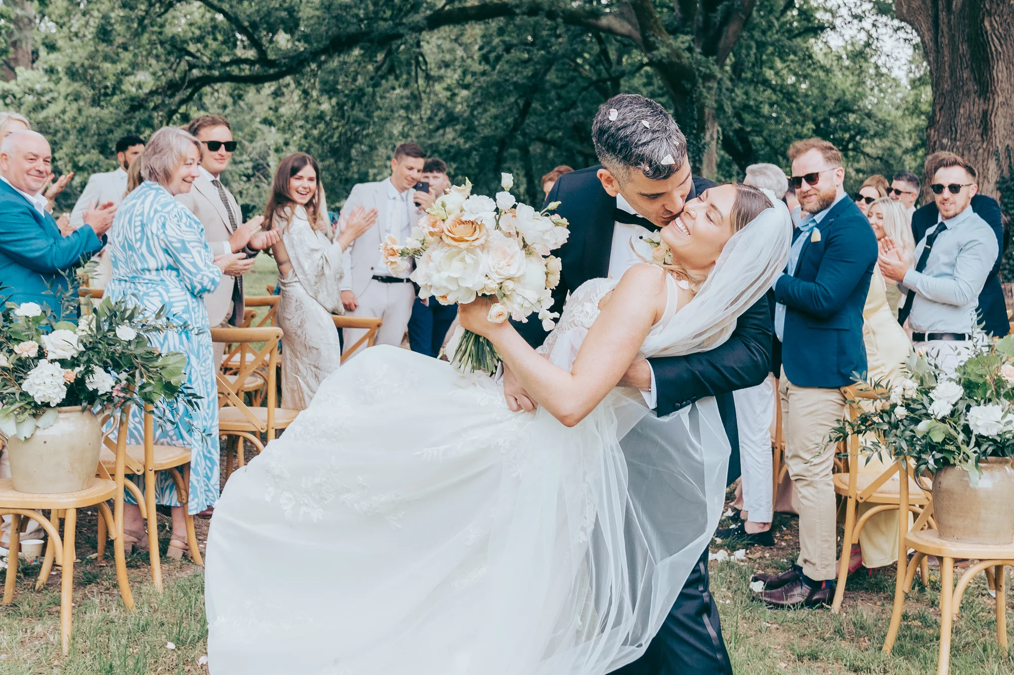 The newlyweds’ kiss under a shower of petals