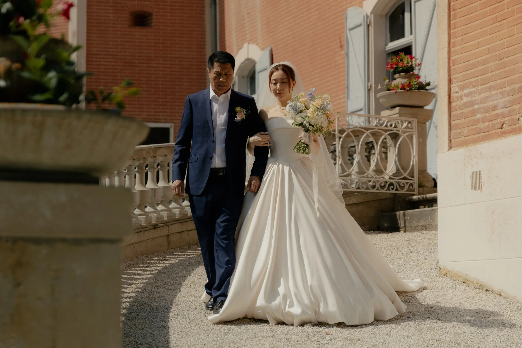 The bride and her father on the steps of the château